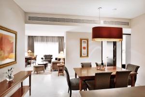 a dining room and living room with a table and chairs at Marriott Suites Pune in Pune