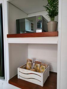 a shelf with a microwave and a box of bread at Appartamento Fontesecco in LʼAquila