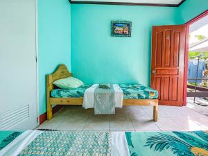 莫阿爾博阿的住宿－Krismark Dive Lodge，一间卧室设有一张床和蓝色的墙壁