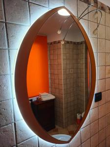 a bathroom with an oval mirror on a wall at Appartamento Fontesecco in LʼAquila
