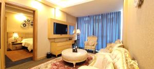 a living room with a couch and a television in a hotel room at Al Sahla Land Hotel in An Najaf