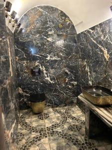 a bathroom with a sink and a black marble wall at The Residence in Luxor +23 photos