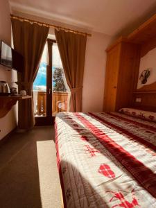 a bedroom with a bed and a large window at Garnì Bonsai in Pinzolo