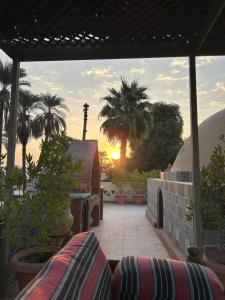 a view of a patio with palm trees and the sunset at The Residence in Luxor