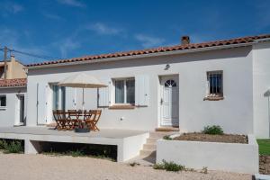 Biały dom z krzesłem i parasolem w obiekcie Villa provençale proche mer au calme w mieście Martigues