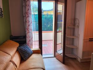 uma sala de estar com um sofá e uma porta de vidro deslizante em Appartamento LA RIBOLLITA em Pesaro