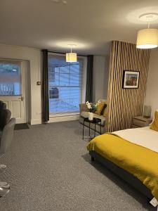 - une chambre avec un lit, une chaise et une fenêtre dans l'établissement The Cozy Apartment, à Gloucester