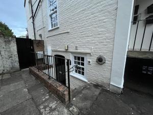 - un bâtiment en briques blanches avec un portail et une fenêtre dans l'établissement The Cozy Apartment, à Gloucester