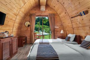 - une chambre avec 2 lits dans une cabane en bois dans l'établissement Pod Village by Independence Hotels, à Sihanoukville