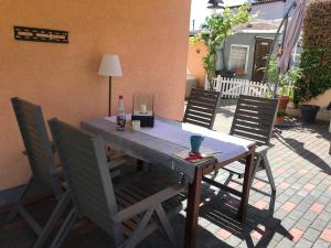 a wooden table with chairs and a lamp on a patio at Pension Doreen Nieswand in Gamstädt