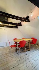 a dining room with a table and red chairs at ApartmentInCopenhagen Apartment 1571 in Copenhagen