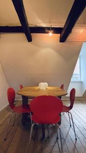 a table with red chairs in a room at ApartmentInCopenhagen Apartment 1571 in Copenhagen