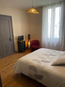 ein Schlafzimmer mit einem Bett, einem Stuhl und einem Fenster in der Unterkunft Chambre privée et sa salle de bain attenante in Mazamet