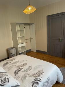 1 dormitorio con 1 cama con edredón blanco y negro en Chambre privée et sa salle de bain attenante en Mazamet