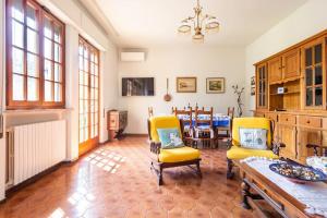 - un salon avec deux chaises jaunes et une table dans l'établissement Villa Giulia, à Capannori