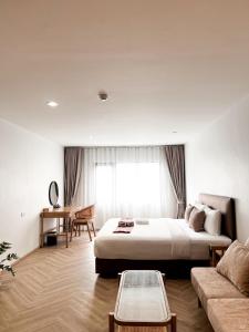 SO Zen Hotel Silom Bangkok في بانغ راك: غرفه فندقيه بسرير واريكه