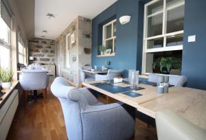 a dining room with blue walls and a wooden table and chairs at Temple View Hotel in Carinish