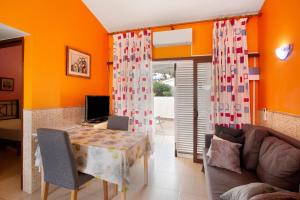 a living room with orange walls and a table and a couch at Haus Brigitte in Playa del Ingles