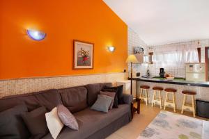 a living room with a couch and an orange wall at Haus Brigitte in Playa del Ingles