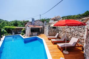 a villa with a swimming pool and a red umbrella at Villa Lily Comfortable holiday residence in Veli Iž