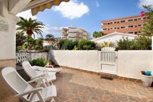 a patio with white chairs and a white fence at Haus Brigitte in Playa del Ingles