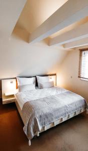 a bedroom with a large bed with white sheets and pillows at Ferienwohnungen am Tor in Langenburg