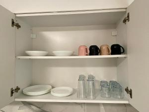 a cupboard with plates and bowls in a kitchen at AVRORA SUITE in Varna City