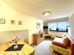 a living room with a table and a couch at Pension Schanzenblick in Kurort Oberwiesenthal