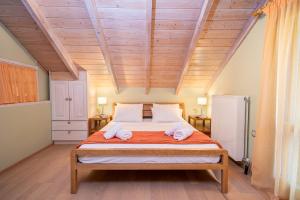 a bedroom with a large bed with two towels on it at ARCHITECT’S VILLA in Fiskardho