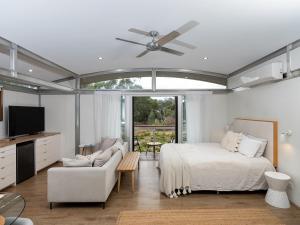 a bedroom with a bed and a couch and a tv at The Villas - Barossa in Marananga