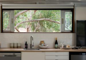 a kitchen with a window above a counter with a sink at The Villas - Barossa in Marananga