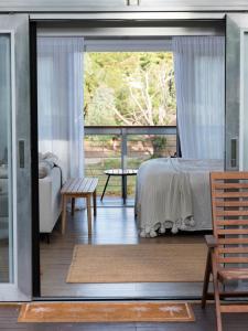a bedroom with a bed and a sliding glass door at The Villas - Barossa in Marananga