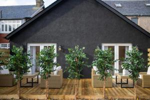 uma casa negra com árvores em frente em The Koko Rooms em Inverness