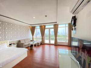 une chambre d'hôtel avec un lit, un canapé et des fenêtres dans l'établissement A25 Hotel - 251 Hai Bà Trưng HCM, à Hô-Chi-Minh-Ville