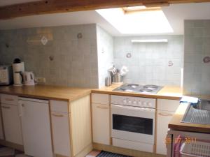 a small kitchen with a stove and a sink at Ferienwohnung Diwoky in Sankt Gilgen