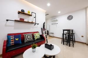 a living room with a red couch and two tables at Olympia City Residence Suite by Caerus Management in Phnom Penh