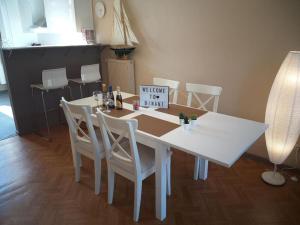 a white dining room table with white chairs and a sign at Appartement The View in Dinant
