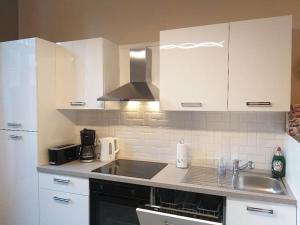 een keuken met witte kasten en een wastafel bij Appartement The View in Dinant