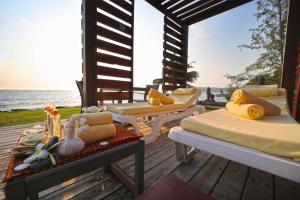 - une terrasse couverte avec des lits et des chaises sur la plage dans l'établissement Pod Village by Independence Hotels, à Sihanoukville