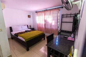 Dormitorio pequeño con cama y mesa en CENTRAL BACKPACKER en Siem Riep
