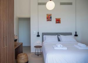 Un dormitorio con una cama con dos toallas encima. en Villa Blauw with Infinity Pool & Sea Views, en Vasiliki 17 fotos más
