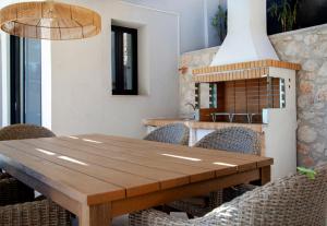mesa de comedor con sillas y chimenea en Villa Blauw with Infinity Pool & Sea Views, en Vasiliki