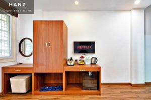 a room with a wooden cabinet with a tv on it at HANZ Ami Central Hanoi in Hanoi
