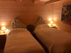 twee bedden in een kamer met twee lampen op tafels bij Cosy Garden Log Cabin in Salisbury