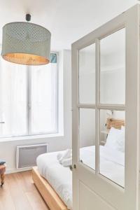 a bedroom with a bed and a glass door at LA LOGE DES CARMES -Coeur de Nantes WIFI in Nantes
