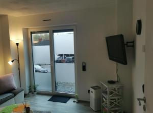 a living room with a tv and a sliding glass door at Apart Bellagast in Hilchenbach