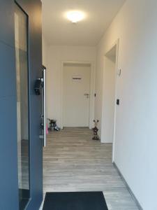 un couloir vide avec une porte et un tapis dans l'établissement Apart Bellagast, à Hilchenbach