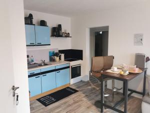 a small kitchen with blue cabinets and a table at Apart Bellagast in Hilchenbach