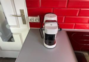 a coffee maker on a counter in a red kitchen at Jolie studio 10min centre ville et 300m quai de seine WIFI in Rouen