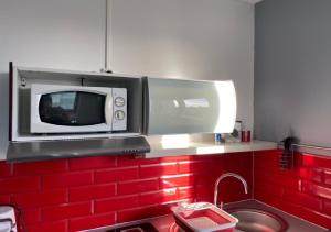 a microwave above a sink in a kitchen at Jolie studio 10min centre ville et 300m quai de seine WIFI in Rouen